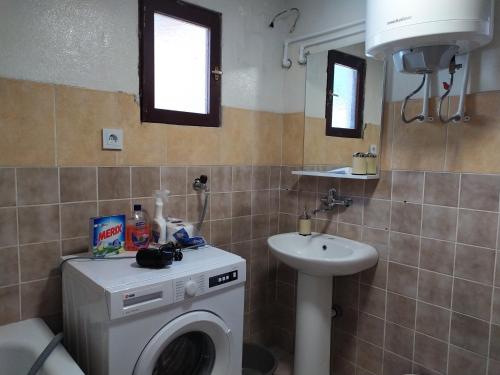 een badkamer met een wasmachine en een wastafel bij Olive House in Petrovac na Moru