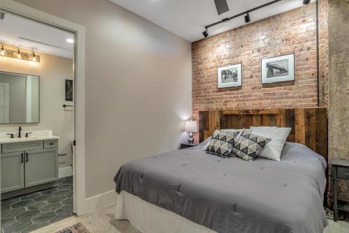 a bedroom with a bed and a brick wall at Exceptional Downtown Condo in Asheville