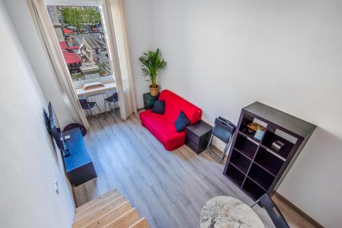 - un salon avec un canapé rouge et une fenêtre dans l'établissement Cours Estienne D'Orves, à Marseille