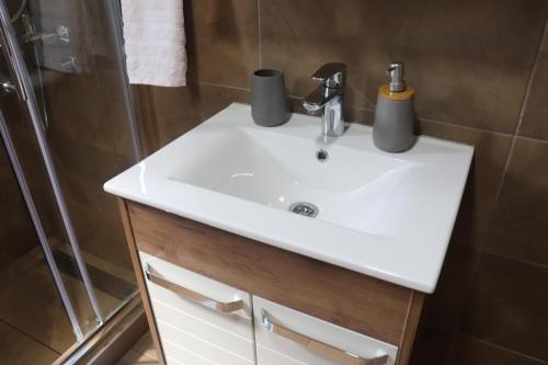 a bathroom with a white sink and a shower at Saint Nicolas Bajina Bašta in Lug