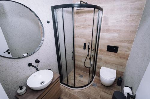 a bathroom with a shower with a sink and a mirror at Vallia Suites-Red Luxury Suite B3 in Nafpaktos
