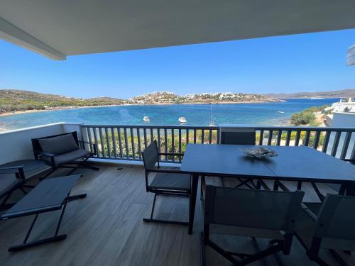 a balcony with tables and chairs and a view of the water at Sounio - Waterfront Luxury Spa Villa Pounta Zeza 170 sqm on Private Beach in Sounio