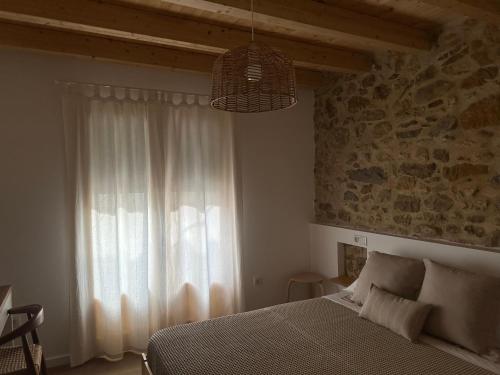 a bedroom with a bed and a large window at Ca Tono Casa Rural in Les Coves de Vinroma