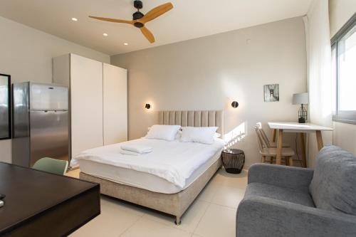 ein Schlafzimmer mit einem Bett und einem Sofa sowie eine Küche in der Unterkunft Carmel Studio By Carmel Boutique in Haifa