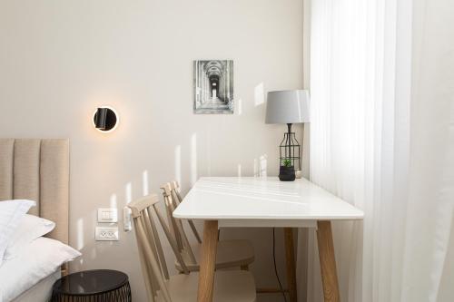 a white table and chairs in a room with a bed at Carmel Studio By Carmel Boutique in Haifa