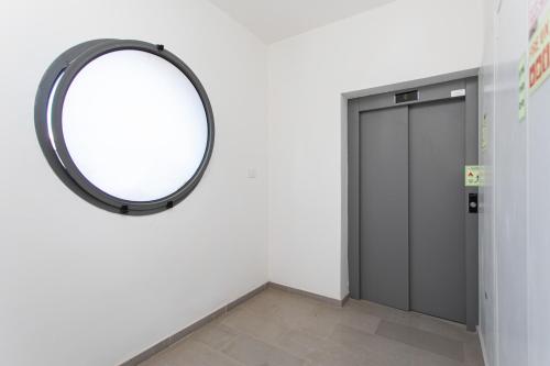 a mirror hanging on a wall next to a door at Carmel Studio By Carmel Boutique in Haifa