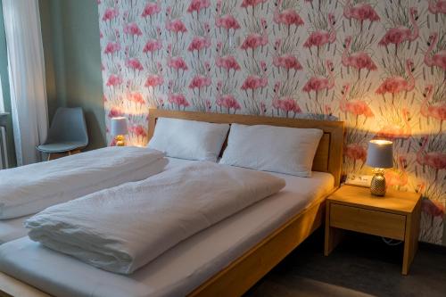 a bedroom with two beds with a floral wallpaper at Ferienwohnung Nadine Petschler in Obereisenheim
