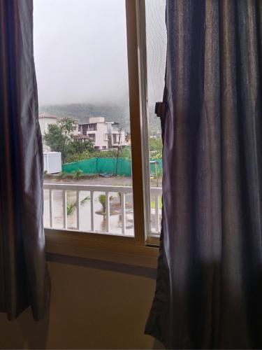 a window with a view of a city at Sky Lawns in Lonavala