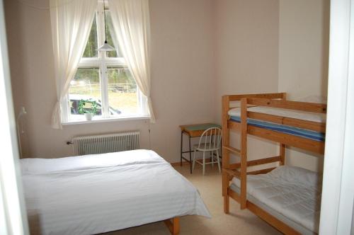 1 dormitorio con 2 literas y ventana en Folsom en Årjäng