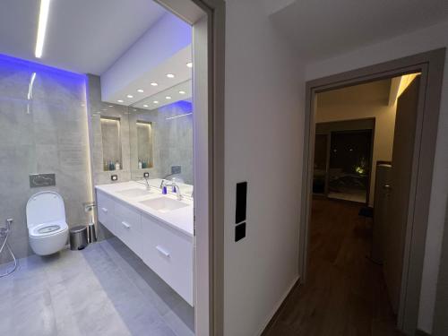 a bathroom with a white sink and a toilet at Sounio - Waterfront Luxury Spa Villa Pounta Zeza 170 sqm on Private Beach in Sounio