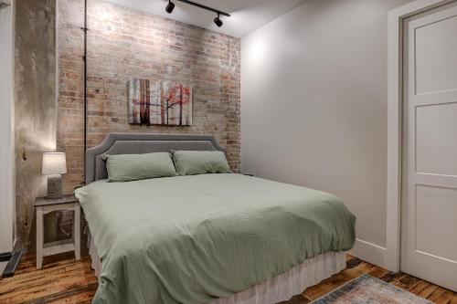 a bedroom with a bed with a brick wall at Fabulous Downtown 2 bedroom Condo in Asheville
