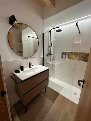 a bathroom with a sink and a shower and a mirror at Ca Tono Casa Rural in Les Coves de Vinroma
