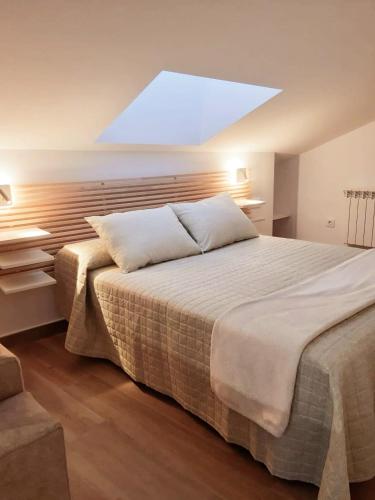 a bedroom with a large bed with a skylight at Vive el Renacimiento: Hornazo in Baeza