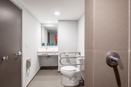 La salle de bains est pourvue de toilettes et d'un lavabo. dans l'établissement City Express Junior by Marriott Ciudad del Carmen Aeropuerto, à Ciudad del Carmen