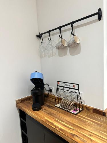 eine Küchentheke mit einem Kleiderständer aus Tassen und einem Mixer in der Unterkunft Papillon de cimiez in Nizza