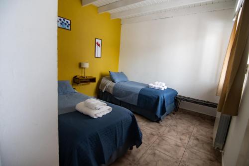 a room with two beds with towels on them at Hosteria Patagonia in El Calafate