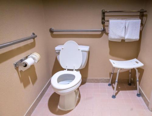 a bathroom with a toilet and a stool at Baymont by Wyndham College Park Atlanta Airport South in Atlanta