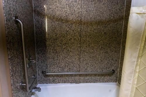 a shower with a glass door and a tub at Baymont by Wyndham College Park Atlanta Airport South in Atlanta