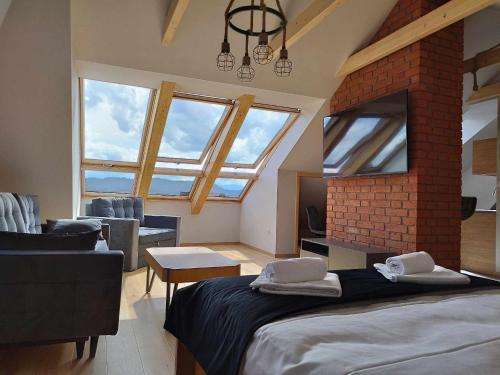 1 dormitorio con 1 cama grande en una habitación con ventanas en Apartament Julia, en Maniowy