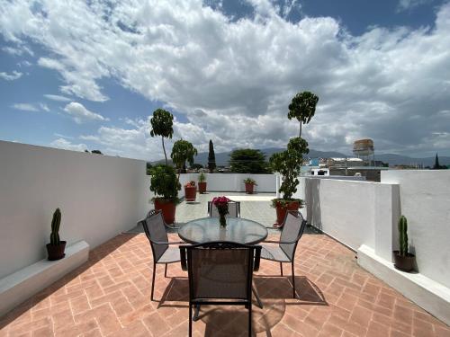 a patio with a table and chairs on a roof at Pent house con terraza o departamento con balcón en el centro de oaxaca in Oaxaca City