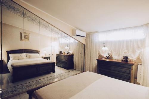 een slaapkamer met een bed en twee dressoires. bij La Maison de Monique - Luxury Villa - 8 Beds, Outdoor Fireplace, Golf! in Marco Simone
