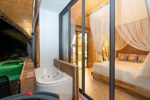 Three Monkeys Villas في شاطيء باتونغ: حمام مع حوض وغرفة نوم مع سرير