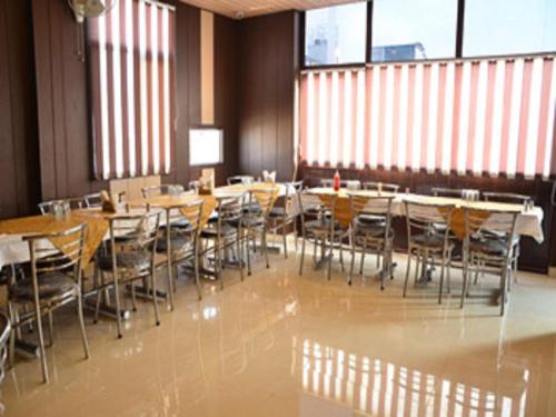 a dining room with tables and chairs and windows at Hotel Popular in Amritsar