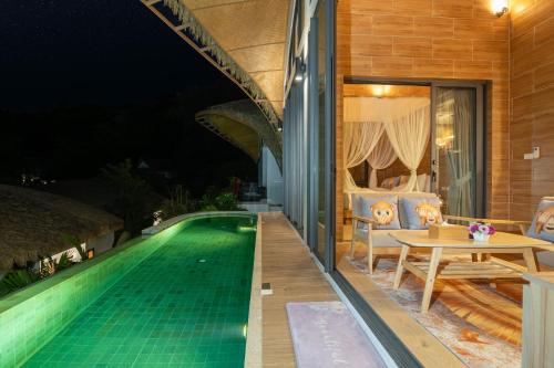 a house with a swimming pool at night at Three Monkeys Villas in Patong Beach