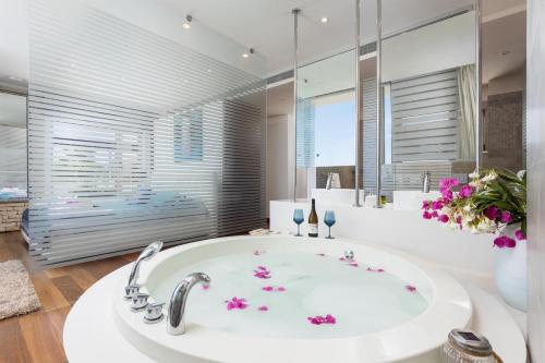 ein Badezimmer mit einer großen weißen Badewanne mit Blumen darauf in der Unterkunft Annabel Beach Palace in Lachi