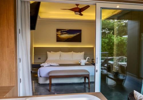 1 dormitorio con 1 cama y ventilador de techo en Luxurious Apartments With BBQ Pool Garden Jungle View, en Akumal