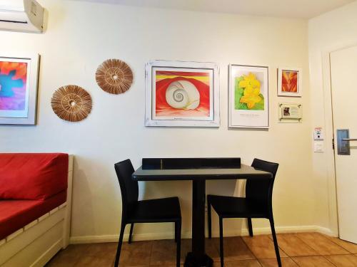 a room with a table and chairs and paintings on the wall at Belle Arti Pousada in Florianópolis