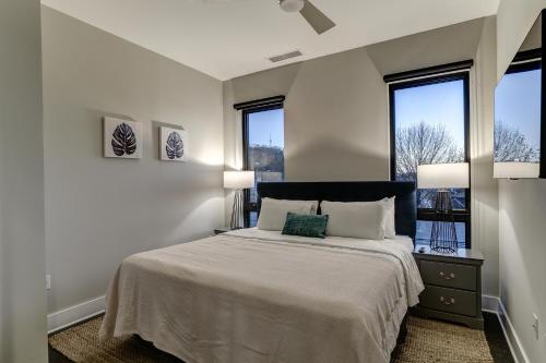 a bedroom with a large bed with two windows at 145 Biltmore Ave Condo 541B0A in Asheville