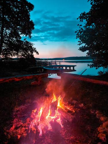 a fire in the grass next to a body of water at Bobrowa Ostoja in Łukta