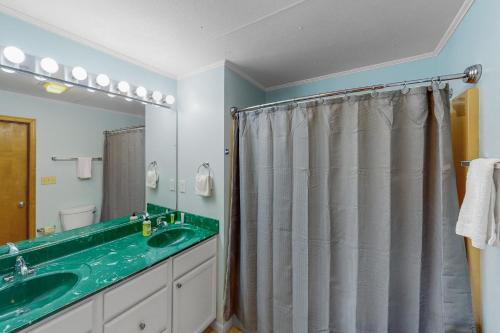 a bathroom with a sink and a shower curtain at Sand Dollar #13-HC in Avon