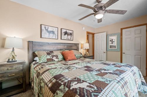 a bedroom with a bed and a ceiling fan at Coy Cottage - NEAR OKTOBERFEST! Calm & quite location within minuets of the heart of town! in Big Bear City