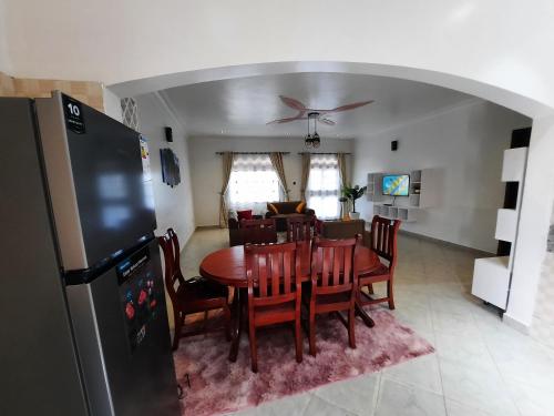 a kitchen and dining room with a table and a refrigerator at Deerwood Family Apartments, Bulenga in Bulenga