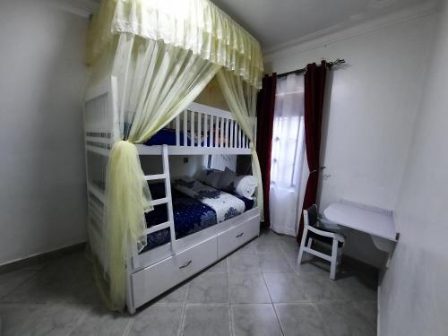 a bedroom with a bunk bed with a canopy at Deerwood Family Apartments, Bulenga in Bulenga