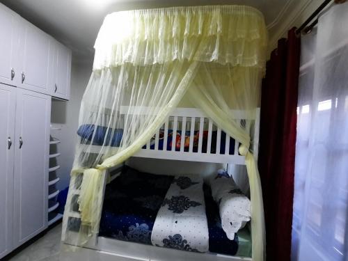 a crib with a canopy in a room at Deerwood Family Apartments, Bulenga in Bulenga