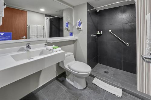 uma casa de banho com um WC, um lavatório e um chuveiro em City Express by Marriott Tapachula em Tapachula