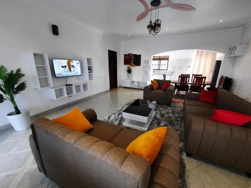 a living room with two couches and a tv at Deerwood Family Apartments, Bulenga in Bulenga
