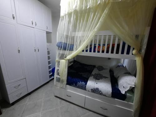 a crib in a room with white cabinets at Deerwood Family Apartments, Bulenga in Bulenga