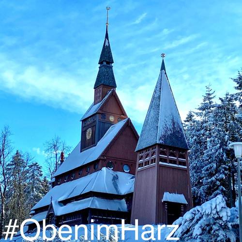 a church with a clock tower in the snow at Harzpur Lodge - Pure Entspannung in purer Natur in Hahnenklee-Bockswiese