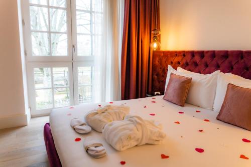 a bedroom with a bed with towels and hearts on it at Hôtel Ginkgo - SPA Biloba in Quimper