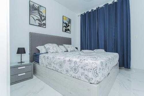 een slaapkamer met een groot bed en blauwe gordijnen bij 246 Home Sweet Memories - Alicante Holiday in Benijófar