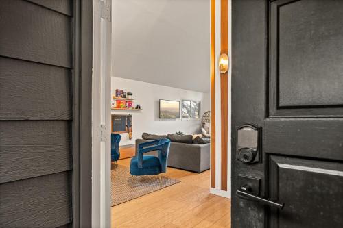 a door leading to a living room with a couch at Modern Treetop Cabin by Lake Arrowhead Village in Lake Arrowhead
