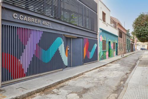 un edificio con un mural en el lateral de una calle en Palermo Soho Lofts at Cabrer en Buenos Aires