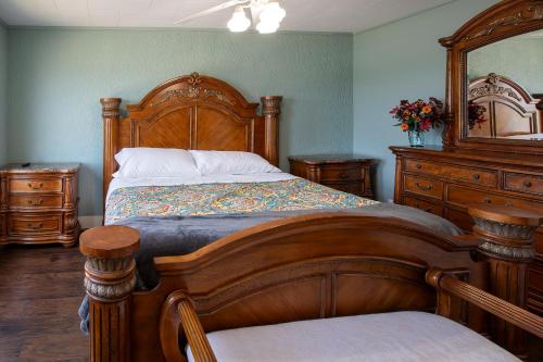 a bedroom with a wooden bed and a dresser at Big River Escape Grandview Manse in Minneiska
