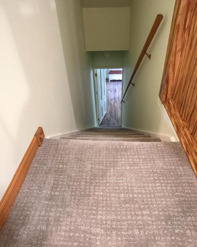 an empty room with a wooden door and stairs at Big River Escape Grandview Manse in Minneiska