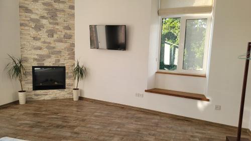 a living room with a fireplace and a tv on a wall at Апартаменти біля Фортеці in Kamianets-Podilskyi