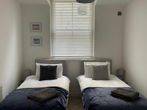 two beds sitting in a room with a window at Beachside Mews in Broadstairs